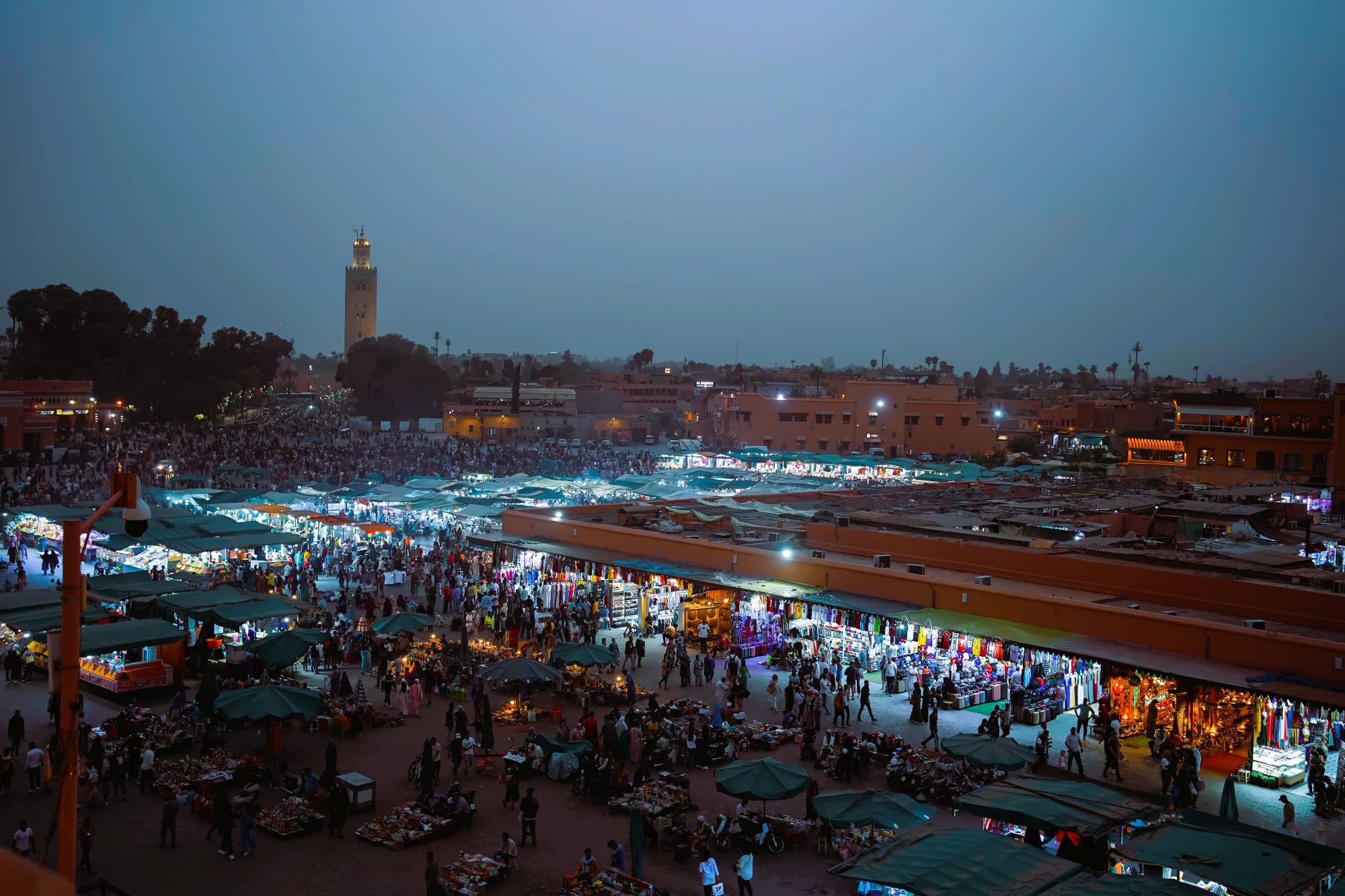 Food stalls and crowds filling Jemaa el-Fnaa square at dusk with smoke rising above the lights