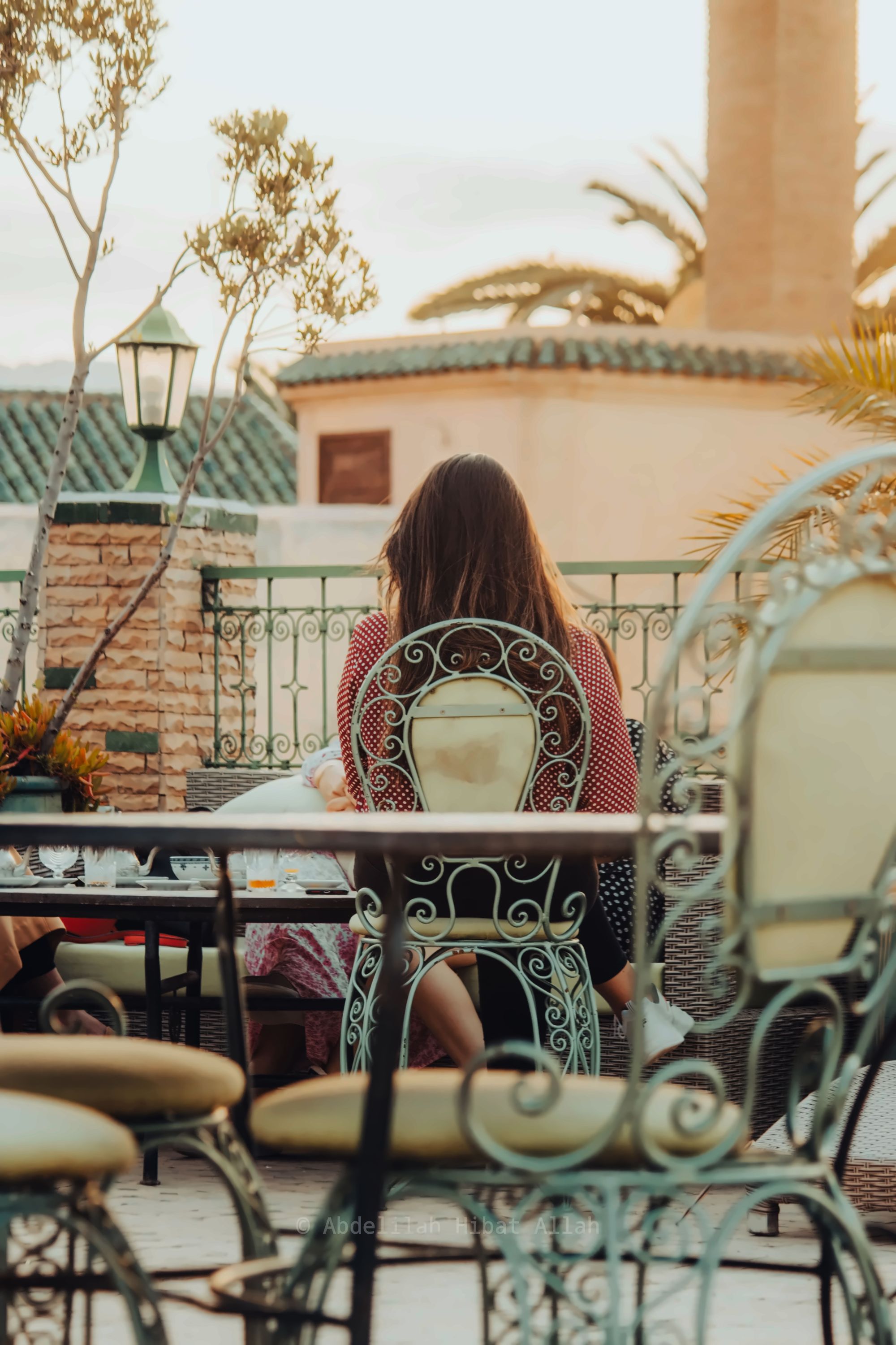 Mint tea poured from a height into small glasses on a rooftop terrace overlooking the Marrakech medina