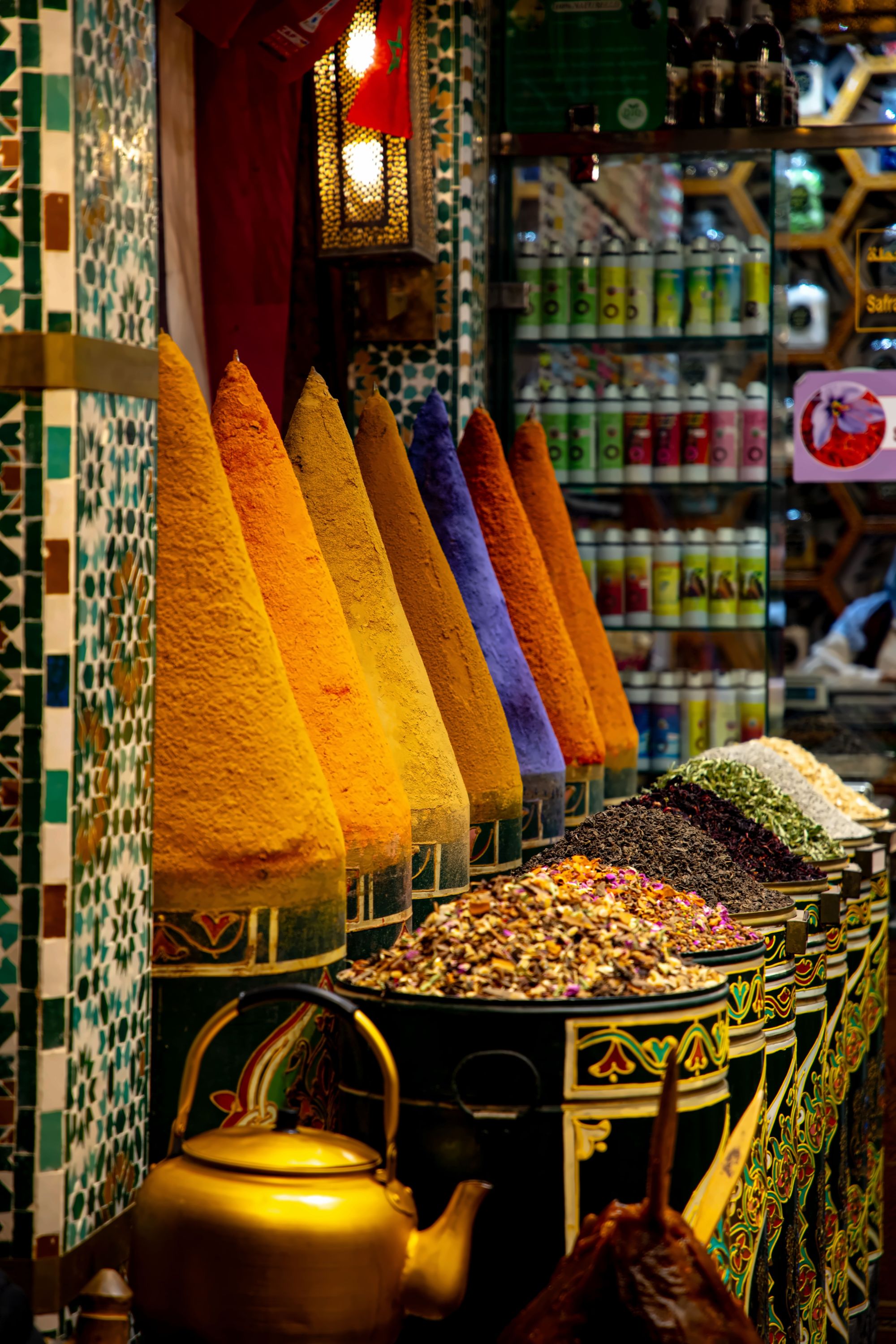 Pyramids of saffron and cumin glowing under shafts of light in a covered Marrakech souk alley