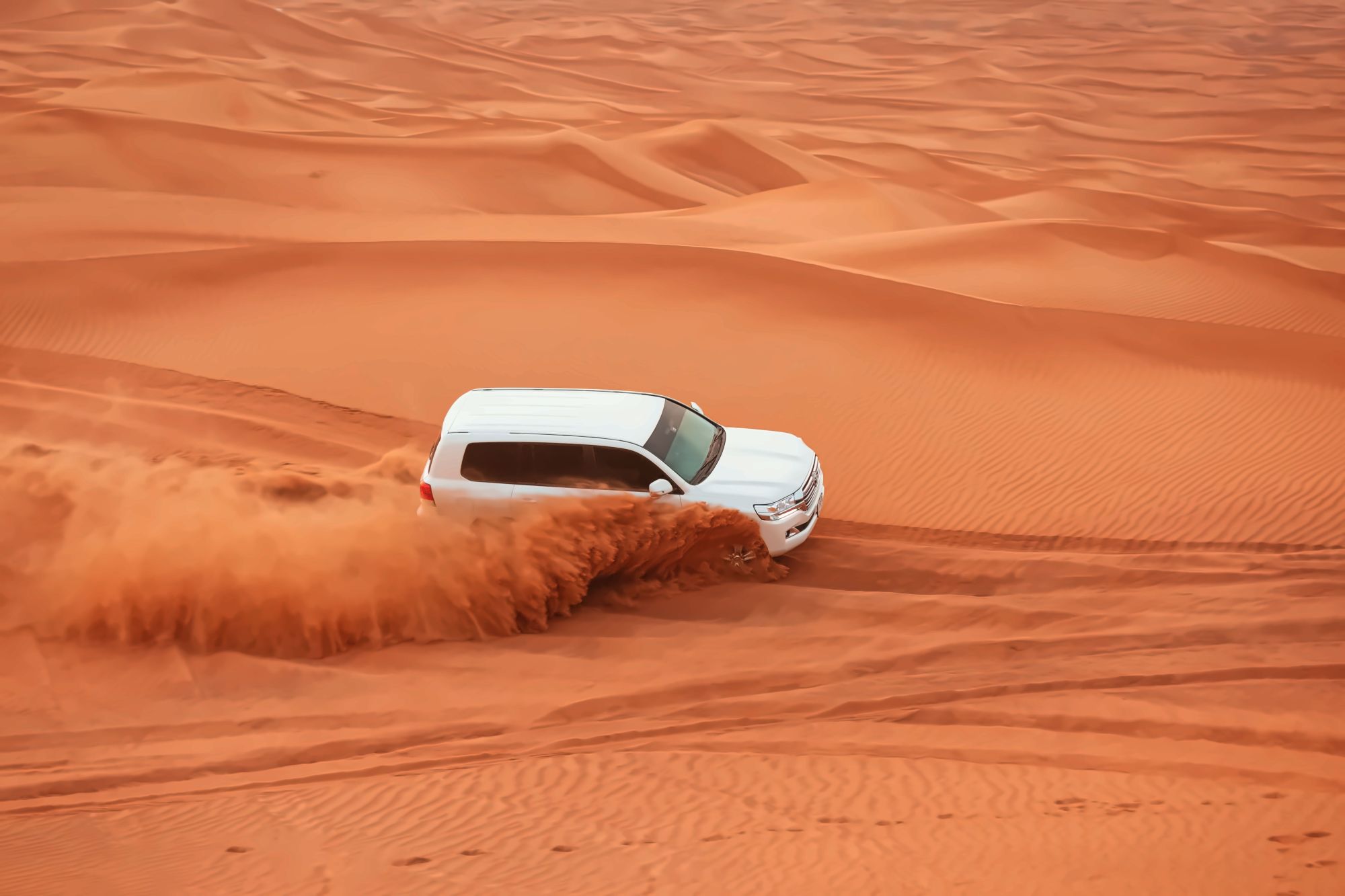 A 4x4 vehicle crossing the soft sand waves of Erg Chebbi on a desert excursion