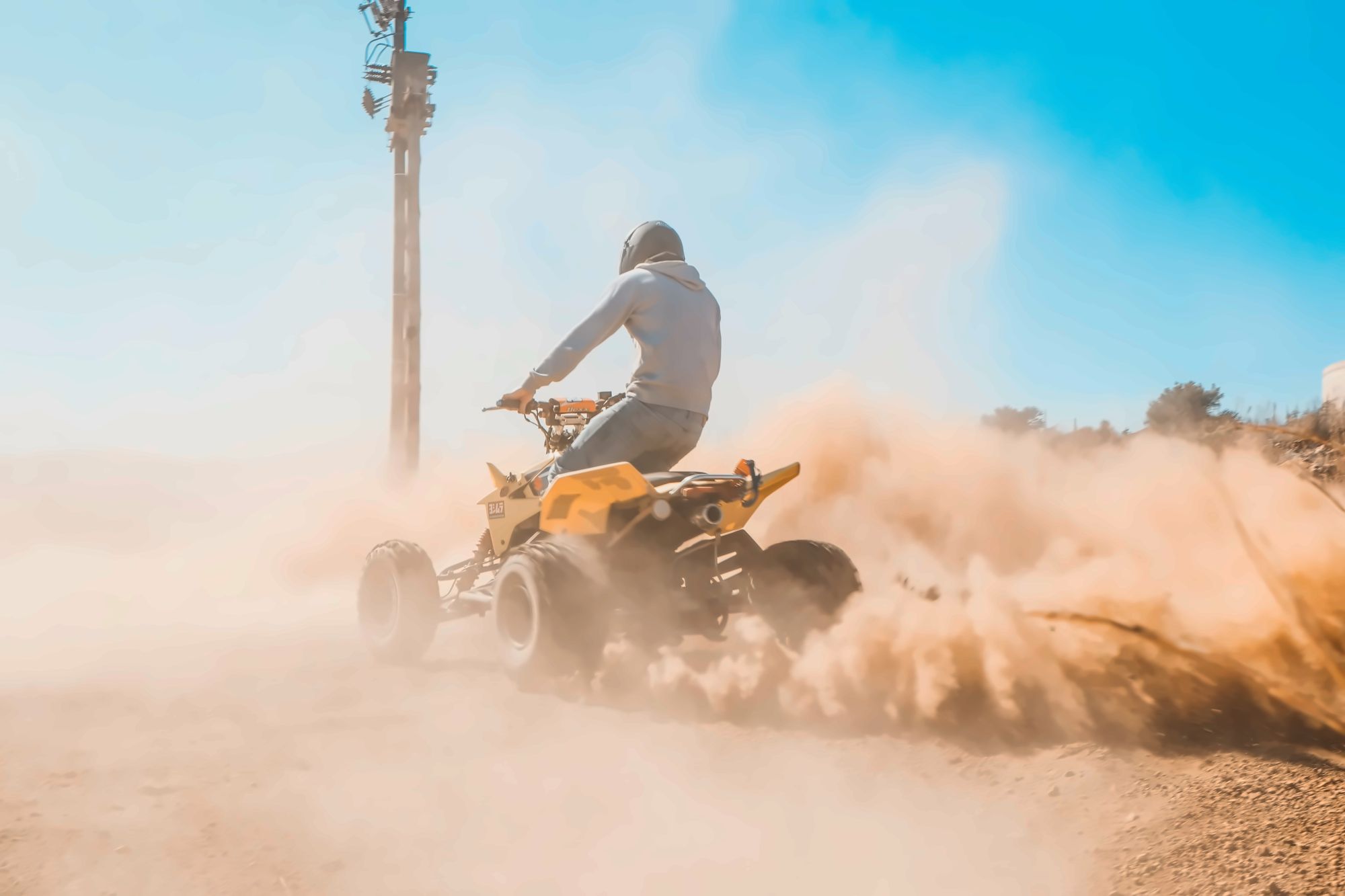 Quad bikes on a dusty track winding through argan trees in the hills behind Taghazout